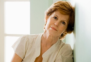 Older woman leaning on wall