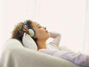 Woman laying down while wearing headphones