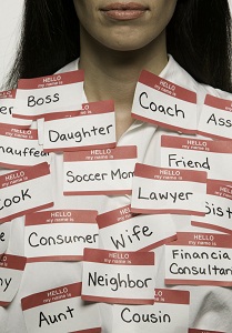 A woman with stickers on her shirt, labeling her roles in life