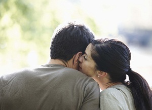 Woman whispering in man's ear