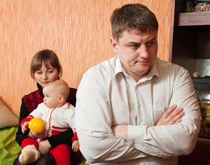 Annoyed looking man with family in background