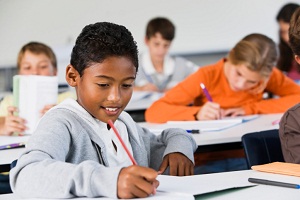 Boy doing homework in classroom