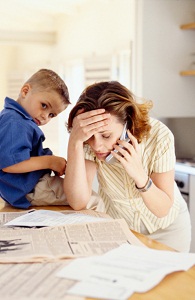Stressed mother on phone with son nearby