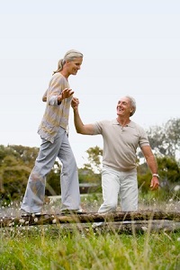 Man helping woman balance on log