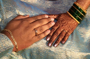 Two hands, one with African tattoos