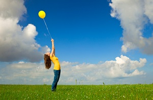 Girl with balloon in field