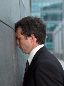 Man leaning his face on a wall