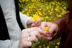 Two people pulling petals off flowers