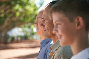 Boy, father and grandfather sitting in row