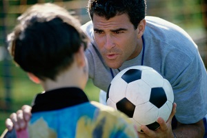 Soccer coach talking to young boy