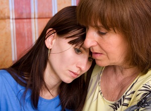 Mother comforting adult daughter