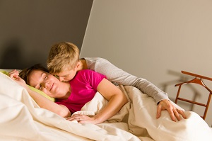 Man cuddles up to his wife in bed