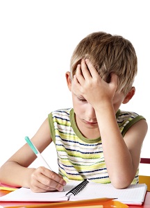 Boy with hand on forehead doing homework
