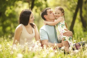 Happy mother, father and daughter in the park