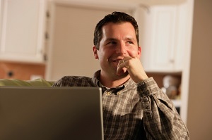 man-smiling-while-using-laptop