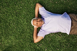 Senior man lying down on grass