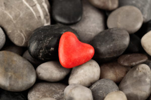 Red stone heart among other small stones