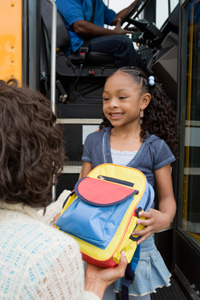 woman-handing-backpack-to-child