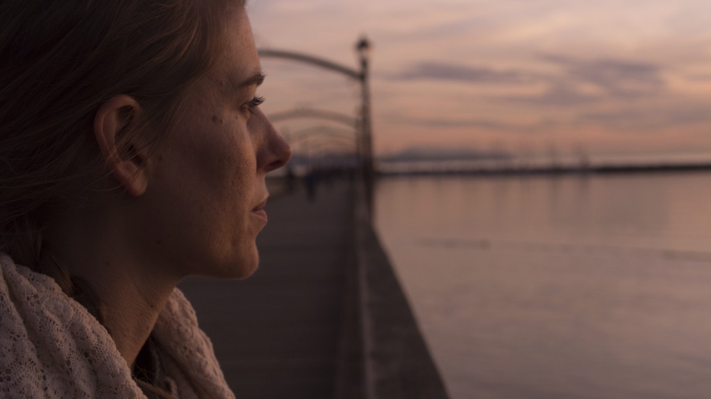 Young woman on pier at sunset.