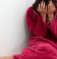 woman crying on floor in bathrobe