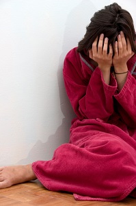 woman crying on floor in bathrobe