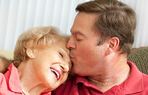 adult son kissing elderly mom