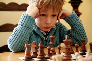 Boy studies chessboard