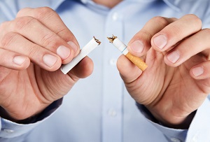 man breaking cigarette in half