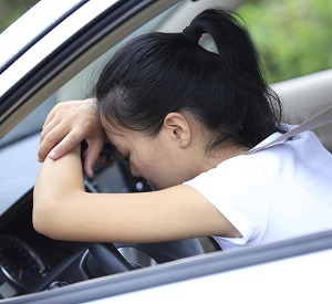 Sad woman sitting in her car