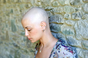woman with shaved head looking sad