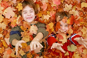 young boys playing in leaves