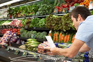man reading shopping list in grocery store