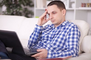 man on laptop looking sad