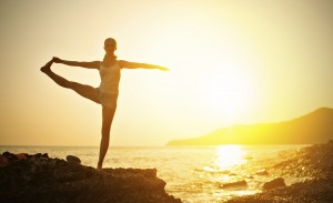 woman doing a yoga stretch at sunset