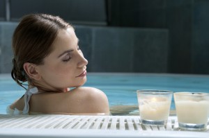 A woman soaks in the hot tub at a spa.