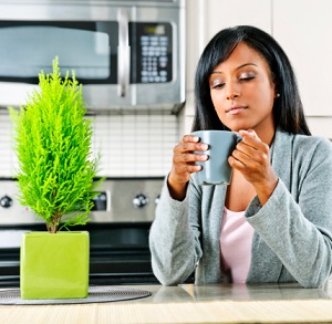 Woman in kitchen with coffee cup