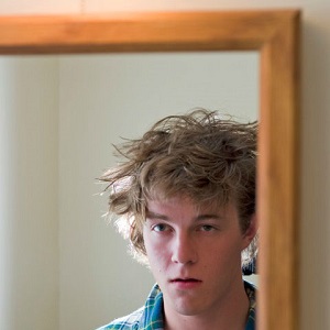 young man looking into mirror
