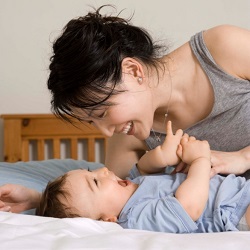 Mother playing with son on bed