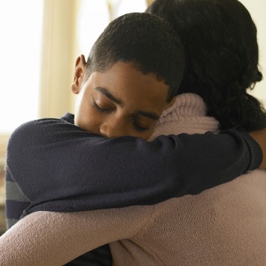 Boy hugging mother at home
