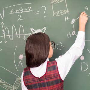young girl writing on chalkboard