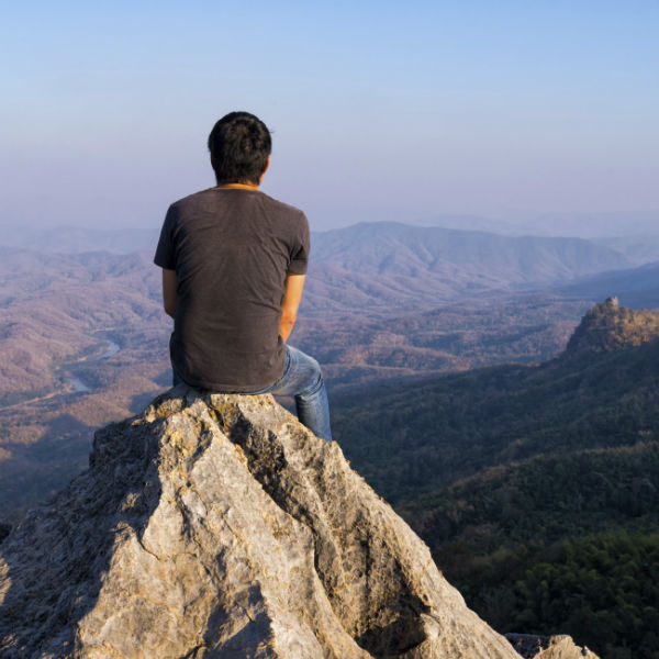 man atop mountain peak