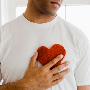 Man holding heart shape on chest