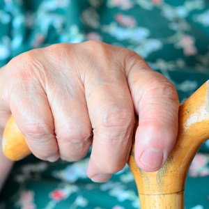 senior person's hand on cane