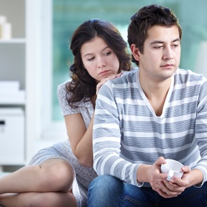 troubled couple sitting on bet
