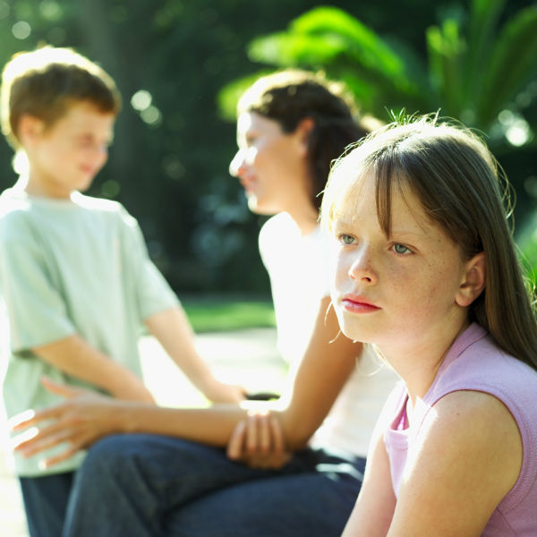 envious girl with mom and sibling in the background