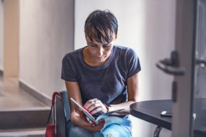 Woman sitting in waiting room, reading a book