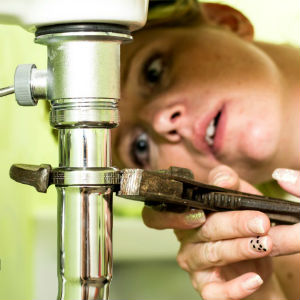 woman fixing a leaky sink