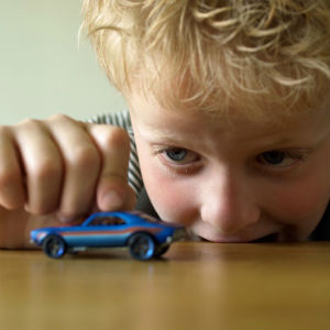 child playing with toy car