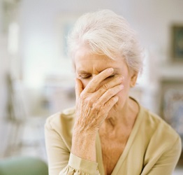 Distressed senior woman with her hand on her face