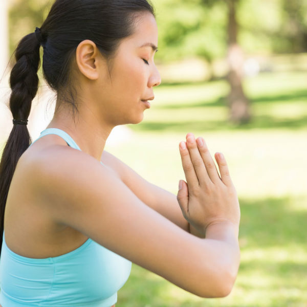 woman practicing yoga in a park